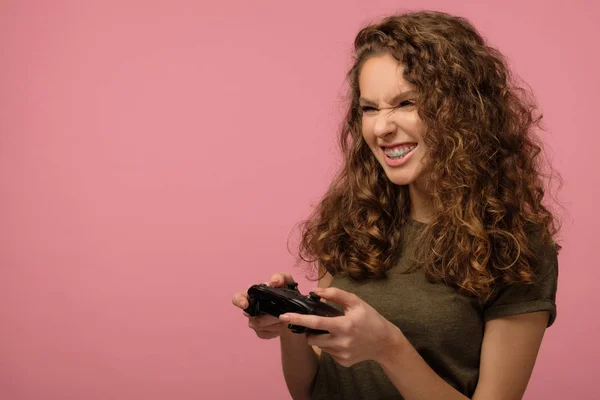 Söt nörd flicka med gamepad på rosa bakgrund — Stockfoto