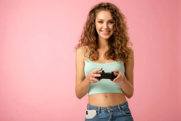 Söt nörd flicka med gamepad på rosa bakgrund — Stockfoto