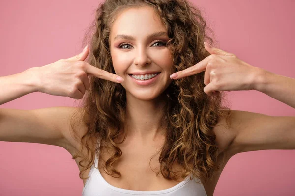 Menina atraente com cabelo encaracolado isolado em rosa — Fotografia de Stock