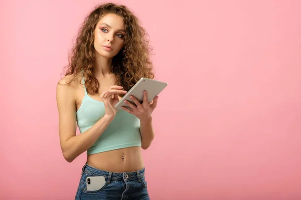 Chica atractiva con el comprimido aislado en rosa —  Fotos de Stock