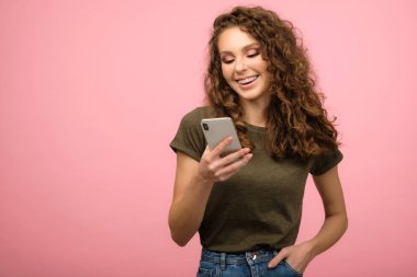 Akıllı telefonlu güzel bir öğrencinin stüdyo portresi.