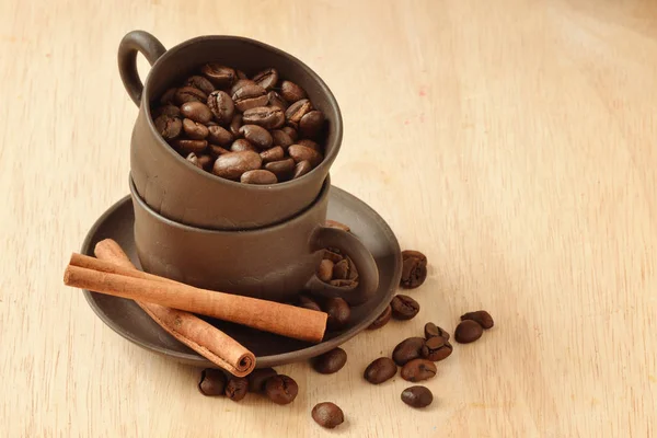 Kahve çekirdekleri fincan ve tarçın çubukları içinde — Stok fotoğraf