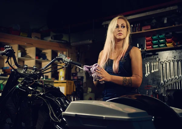 Blonďatá žena mechanik v servisu motocyklu — Stock fotografie