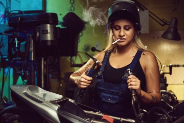 Bir motosiklet atölyede çalışan kadın makinist