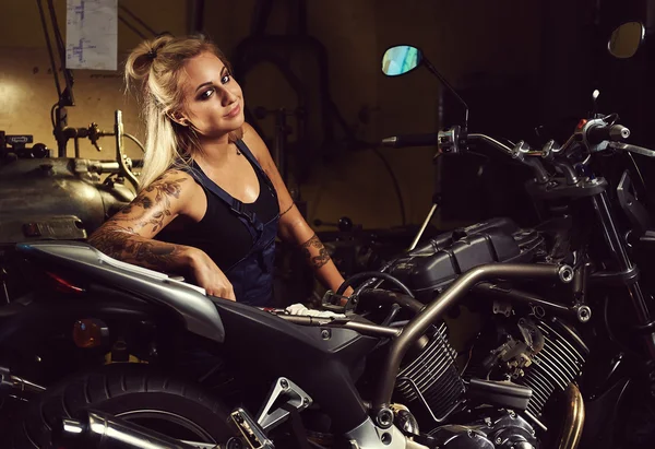 Mujer rubia mecánica en un taller de motocicletas —  Fotos de Stock