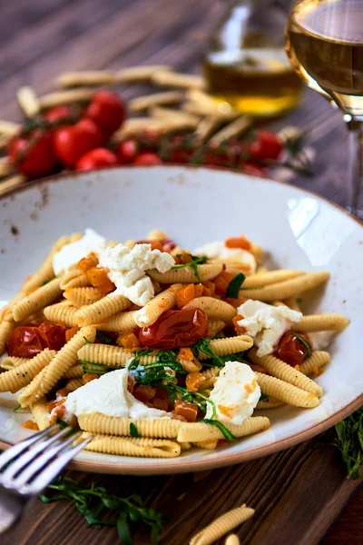 Makarony wegetariańskie, przyozdobionym z pomidora, sera i świeżych ziół — Zdjęcie stockowe