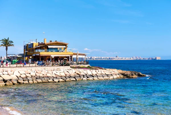 Touristen sitzen in einem Café direkt am Meer. Spanien — Stockfoto