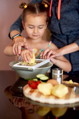 Sevimli küçük kız ve annesi evde yemek