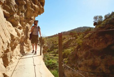 Ahşap yaya köprüsü üzerinde bir dağlar üzerinde yürüyen adam traveler