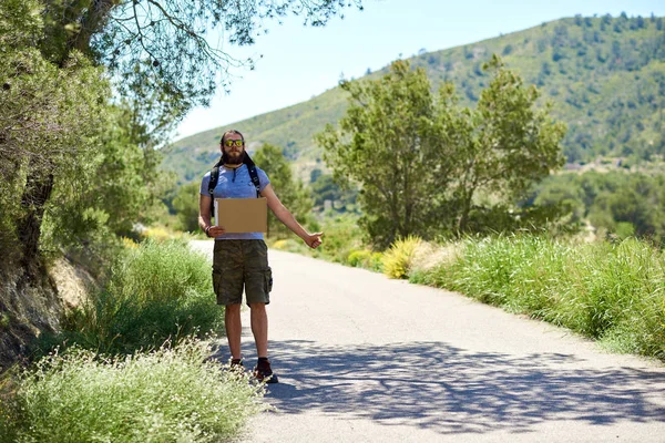 Hitch-hiking traveler with a blank cardboard sign — Stock Photo, Image