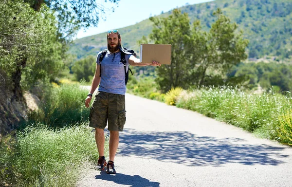 Voyageur auto-stoppeur avec un panneau en carton vierge — Photo