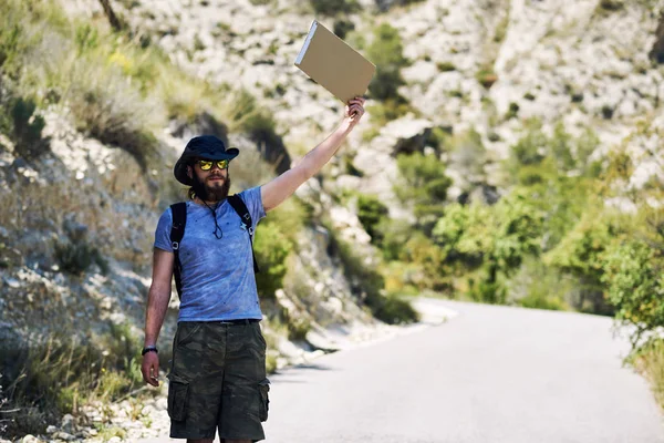 Voyageur auto-stoppeur avec un panneau en carton vierge — Photo