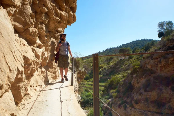 Reiziger van de man lopen op een houten voetgangersbrug op een bergen — Stockfoto