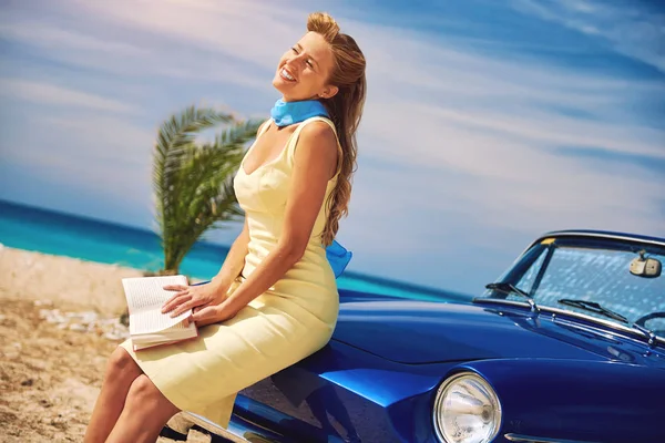 Schöne glückliche Frau mit einem Buch in der Nähe von Retro-Cabriolet-Auto — Stockfoto