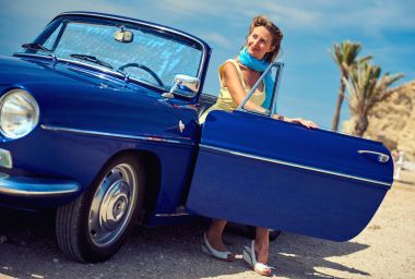 Sahilde retro cabriolet arabada oturan güzel kadın