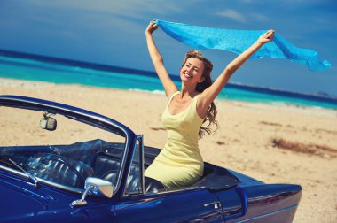 Retro cabriolet arabada oturan mutlu kadın bir eliyle kaldırdı 