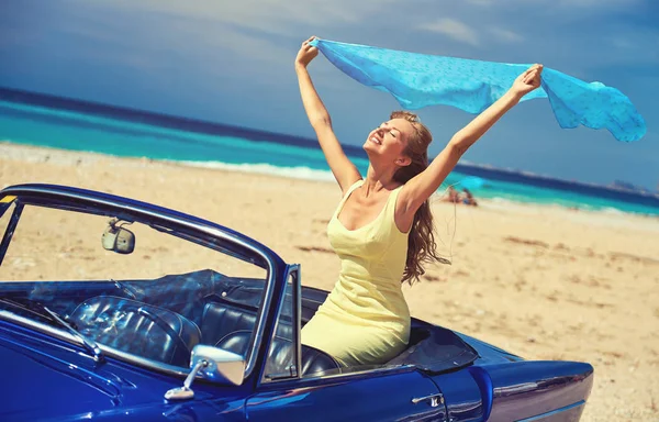Happy woman with a hands raised sitting in retro cabriolet car — Stock Photo, Image