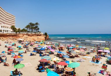 People enjoying the summer on the beach of La Zenia. Spain clipart