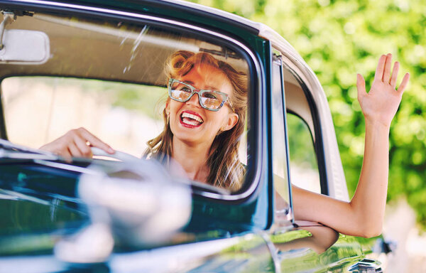 Beautiful happy woman sitting in a car. Retro styled