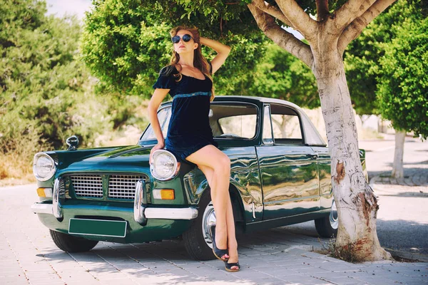 Güzel kadın poz yakınındaki eski model araba