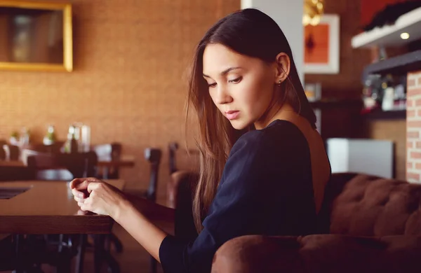 Jonge brunette zittend in een restaurant — Stockfoto