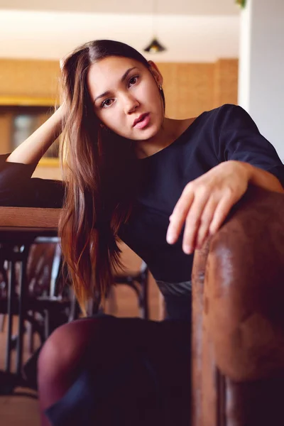 Jonge brunette zittend in een restaurant — Stockfoto