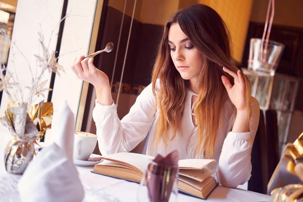 Genç esmer bir restoranda bir kitap okuma