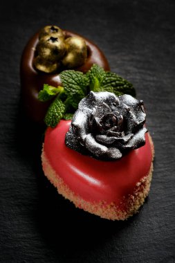 İki kalp kek şekilli gümüş ve altın payet ile dekore edilmiştir.