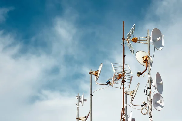 Antennas on a roof against cloudy sky background — Stock Photo, Image