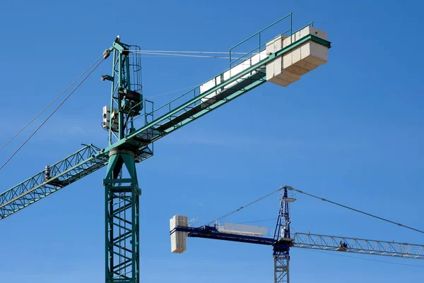 Construction cranes against blue sky — Stock Photo, Image