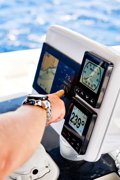 Feche a mão masculina apontando em dispositivos de navegação no convés de catamarã — Fotografia de Stock