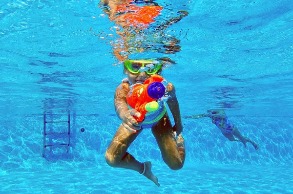 Drôle 6 ou 7 ans petite fille adorable s'amuser plongé dans la piscine visée pistolet à eau à la caméra — Photo