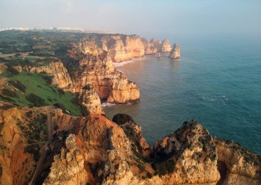 Ponta da Piedade Burnu 'nun panoramik manzarasının üzerinde, kireçtaşı kıyı şeridi boyunca sarı-altın uçurumlar bulunan bir grup kaya oluşumuyla Lagos şehri, Portekiz' in en ünlü turistik merkezi.