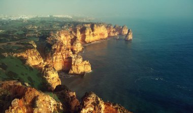 Ponta da Piedade Burnu 'nun üzerindeki hava panoramik görüntüsü. Kireçtaşı kıyı şeridi boyunca bir grup kaya oluşumları, Lagos kasabası, Portekiz' in en ünlü turistik merkezi.