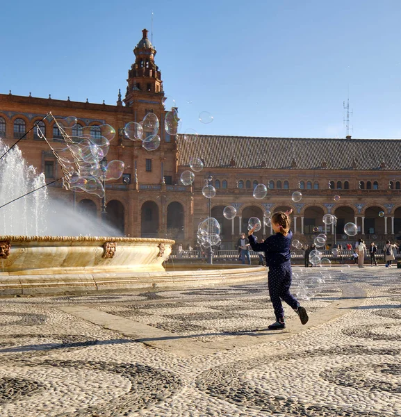 在流行的旅游胜地埃斯帕那广场 Plaza Espana 活泼有趣的小女孩玩肥皂泡游戏 享受闲暇时光 塞维利亚 背景古建筑 西班牙安达卢西亚 — 图库照片