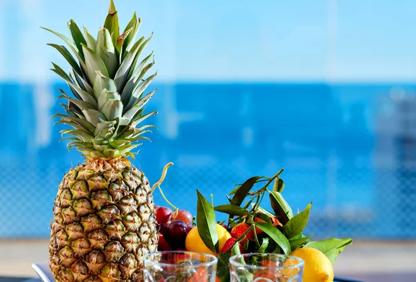 关闭新鲜水果美味的浆果和两个空玻璃杯蓝水游泳池背景 暑假休息和假期 健康的饮食 生活方式没有人室外概念 — 图库照片
