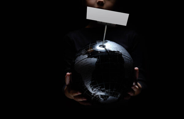 Руки ребенка держат глобус с пустым макетом копировального места на черном фоне. Пандемия COVID-19. Загрязнение окружающей среды, экологическая катастрофа

