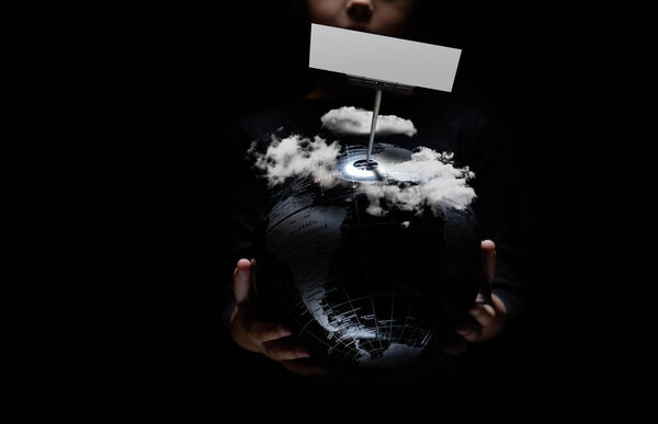 Наша планета под облачным небом концепция загрязнения окружающей среды природного загрязнения катастрофы. Маленькая девочка держит глобус с пустым макетом копировального места на черном. Пандемия коронного вируса
 