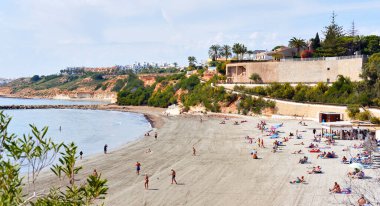 Orihuela, İspanya - 13 Mart 2020: Torrevieja tatil beldesi sahil kentinde bulunan Cabo Roig plajının üzerinde. İnsanlar ılık bahar günlerini Sea, Costa Blanca yakınlarında geçirirler. İspanya