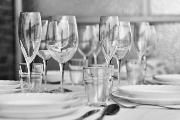 把用白色桌布盛放的各种各样的玻璃器皿和瓷盘关起来 没有人 餐桌布置在家里或餐馆等客人 餐具商店广告 Bw形象概念 — 图库照片