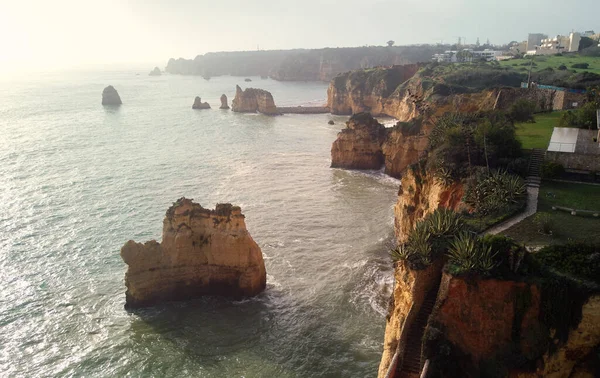 Ponta da Piedade Burnu 'nun panoramik manzarasının üzerinde, kireçtaşı kıyı şeridi boyunca sarı-altın uçurumlar bulunan bir grup kaya oluşumuyla Lagos şehri, Portekiz' in en ünlü turistik merkezi.