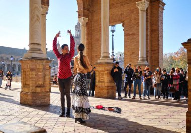 Seville, İspanya - 23 Aralık 2019: Turistler, Plaza de Espana 'daki turistlere yönelik sokak flamenko geleneksel gösterisinin keyfini çıkarıyorlar. Seyahat cazibesi ve eğlence, İspanyol kültürü sanat konsepti imajı