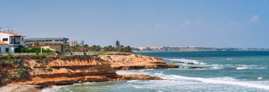 Pilar de la Horada plaj panoramik fotoğrafçılığı, kayalık kıyı şeridi sade manzarası, güneşli sıcak bir günde Akdeniz 'in turkuaz dalgalı suları. Costa Blanca, Alicante ili, Avrupa, İspanya