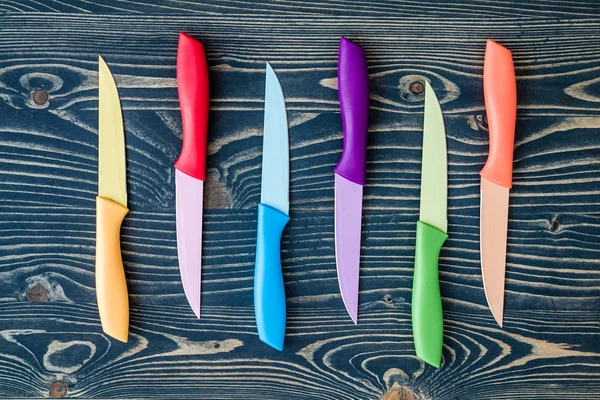 Set of Colorful Kitchen Knives over Blue Wooden Background — Stock Photo, Image