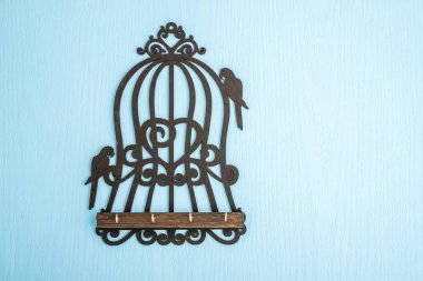 Şeklin üzerindeki mavi ahşap adam ahşap anahtar askıları ile kuş kafes