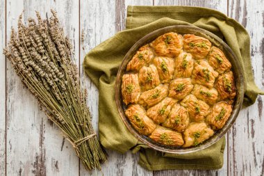 Türk fıstıklı pasta tatlı, baklava tepsisi ve ahşap masa