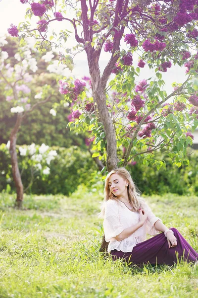 Drömmande kvinna under en lila buske — Stockfoto