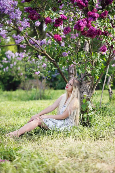 Femme assise sous un buisson lilas — Photo