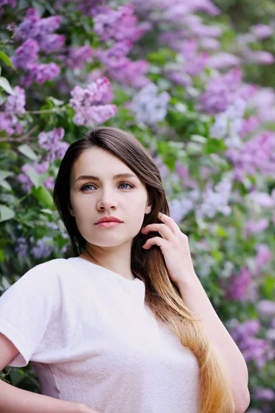 Menina bonita perto do arbusto lilás — Fotografia de Stock