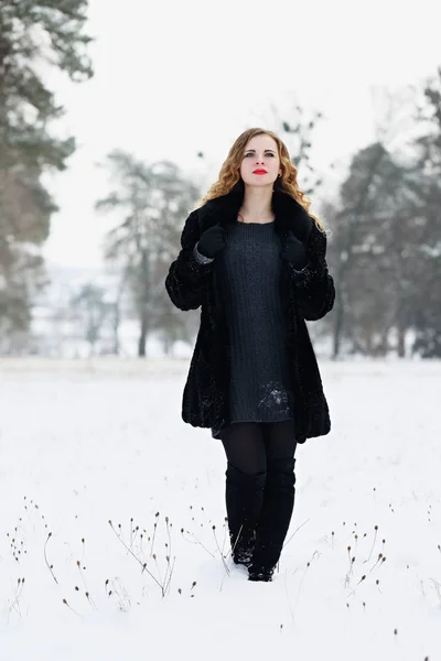 Mujer caminando en un campo cubierto de nieve — Foto de Stock